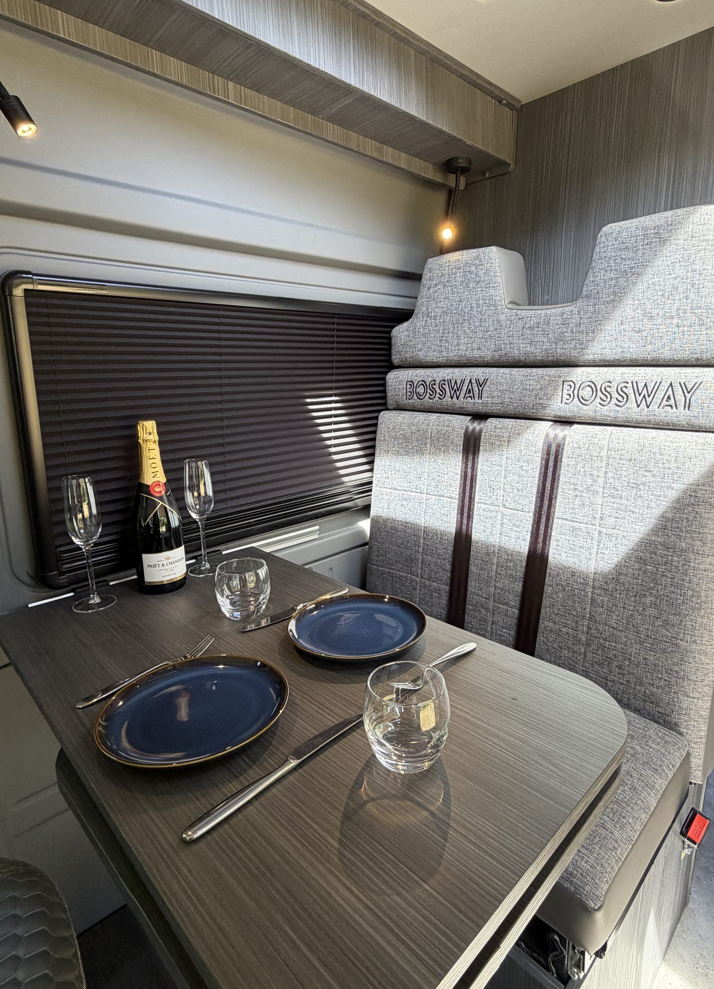 Bossway campervan rear lounge with TV and warm wood cabinetry